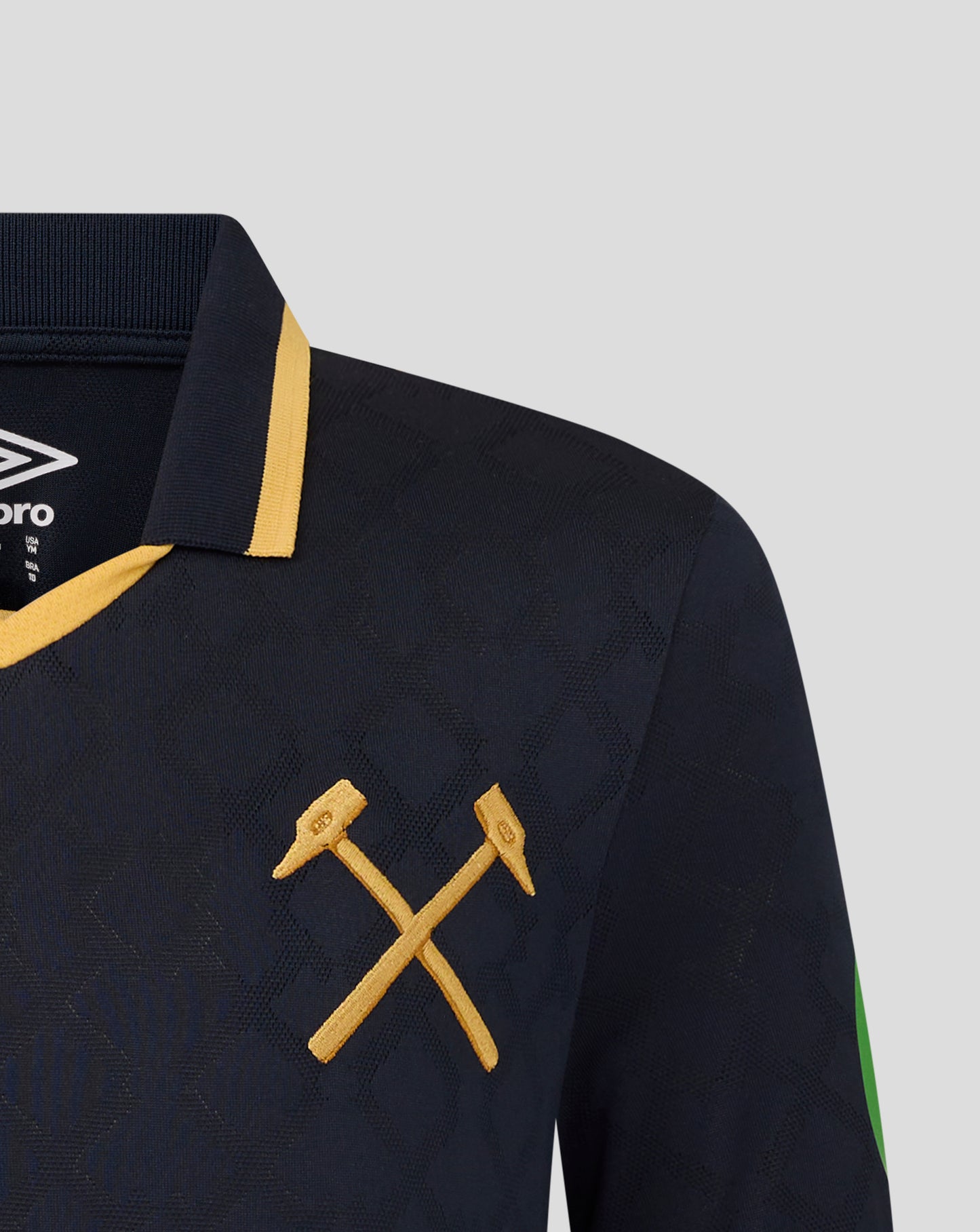 Close-up of navy West Ham Junior 25/26 third kit short sleeve shirt with gold collar trim crossed gold laces and Umbro logo