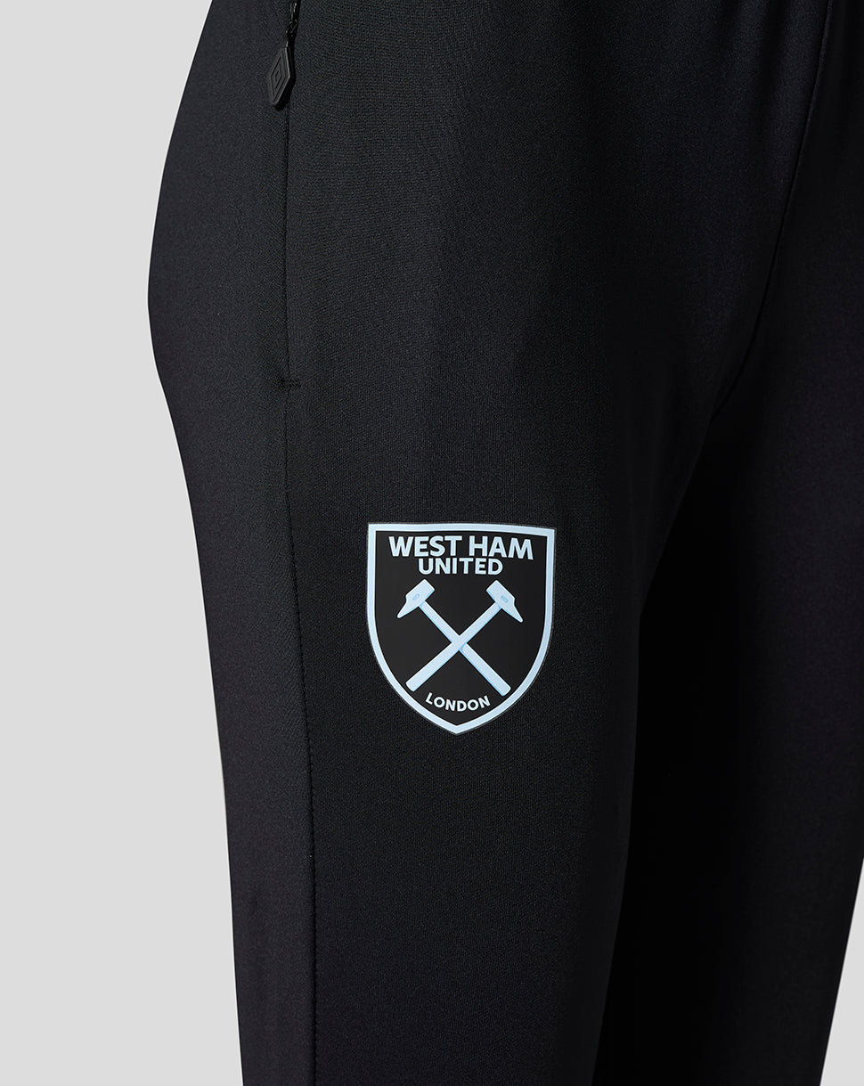 Close-up of Spellbound black pants showing the West Ham United crest on the left thigh and a zipper pull