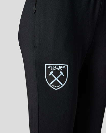 Close-up of Spellbound black pants showing the West Ham United crest on the left thigh and a zipper pull