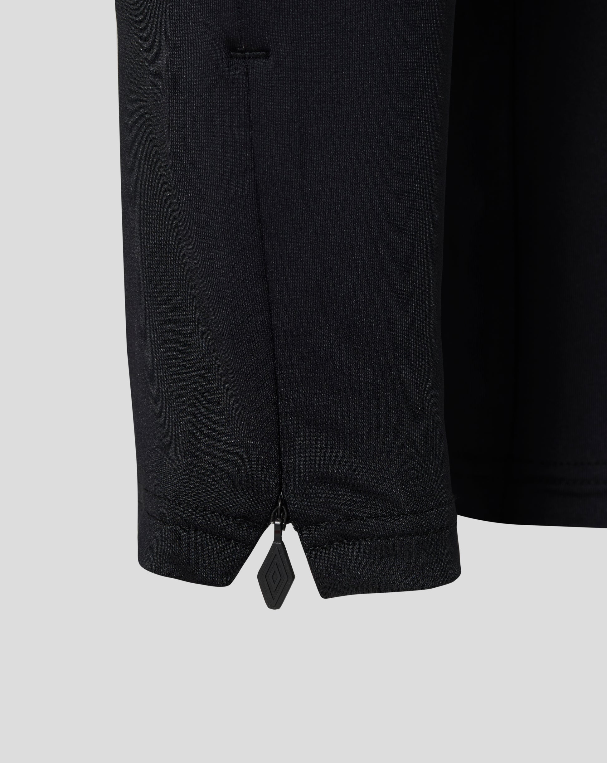 Close up of black West Ham Junior training knit pants leg with a zip at the hem