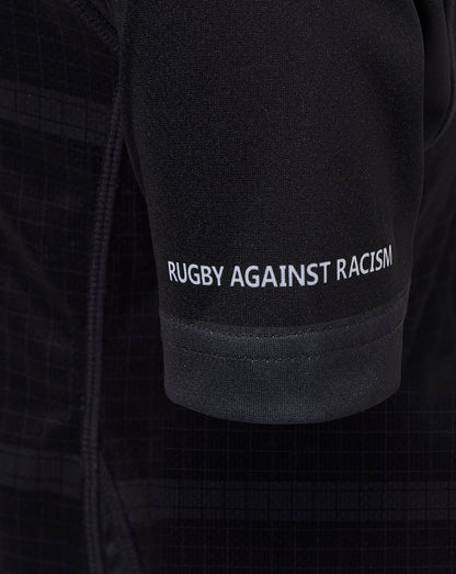Close up of black Bath Rugby junior replica shirt sleeve with Rugby Against Racism slogan in white.