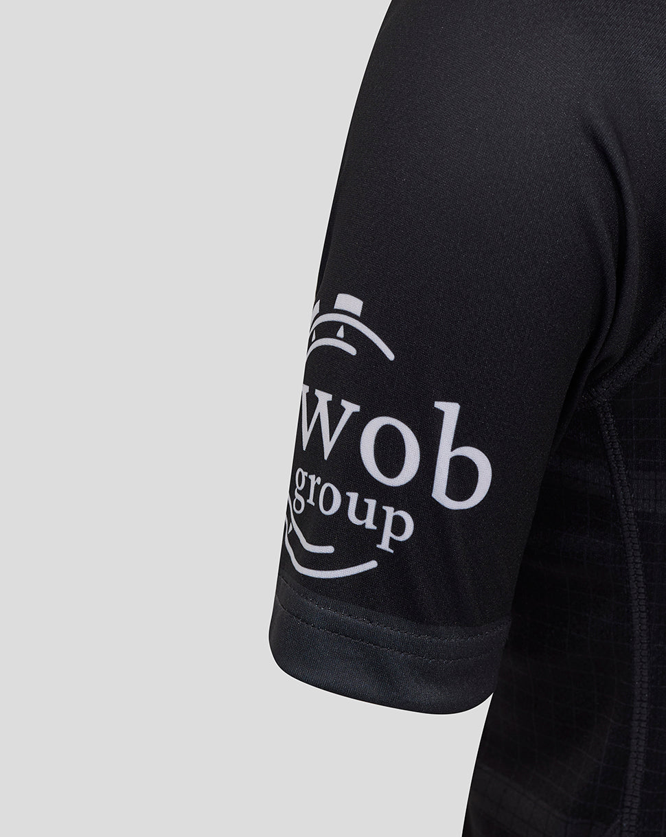 Close up of black Bath Rugby junior replica shirt sleeve with white Wob group logo.