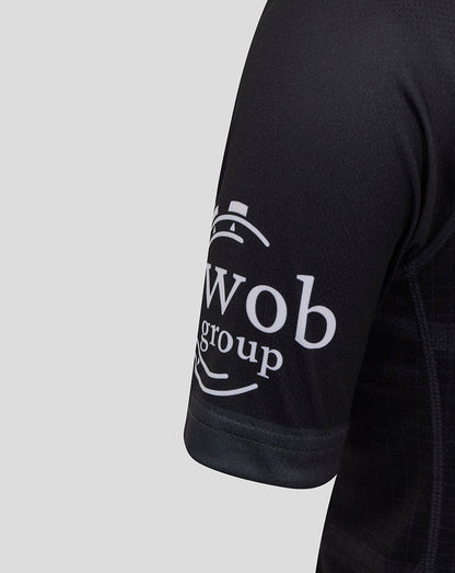 Close up of black Bath Rugby junior replica shirt sleeve with white Wob group logo.