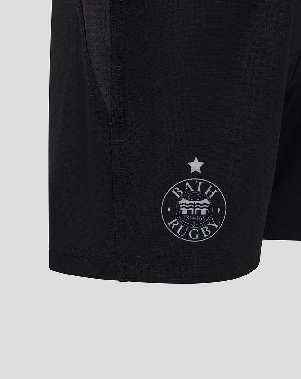 Close up of black Bath Rugby shorts showing the circular Bath Rugby crest near the hem and a star above