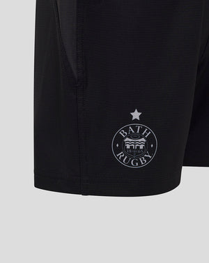 Close up of black Bath Rugby shorts showing the circular Bath Rugby crest near the hem and a star above