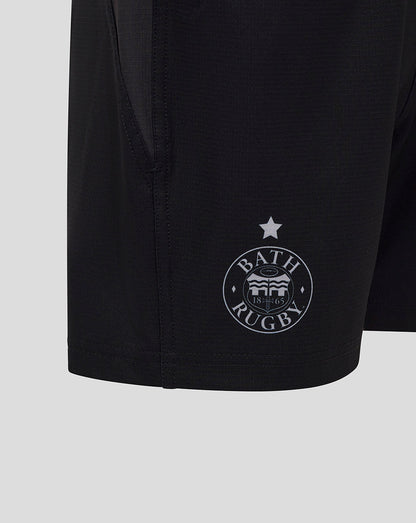 Close up of black Bath Rugby shorts showing the circular Bath Rugby crest near the hem and a star above