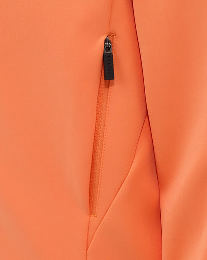 Close up of orange hoodie fabric with a vertical zip pocket and CASTORE branded zipper pull