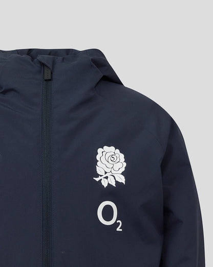 Close-up of navy Junior England Rugby shower jacket chest showing white rose crest and O2 logo beside the front zip.