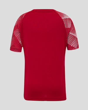 Back view of red England Rugby Junior pre match shirt with geometric white sleeve patterns.
