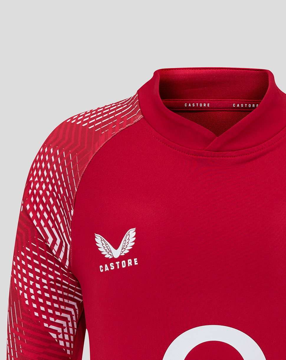 Close up of a red England Rugby junior pre match drill top showing the rose crest on the chest and Castore branding.