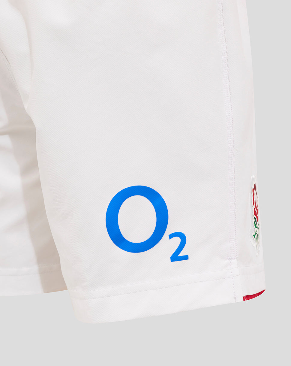Side view of white shorts with blue O2 logo on the leg and embroidered Rose crest near the hem with red trim