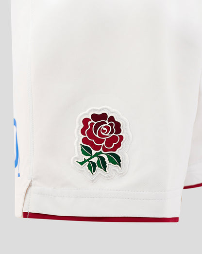 Close up of white shorts fabric showing the embroidered Rose crest patch on the left thigh