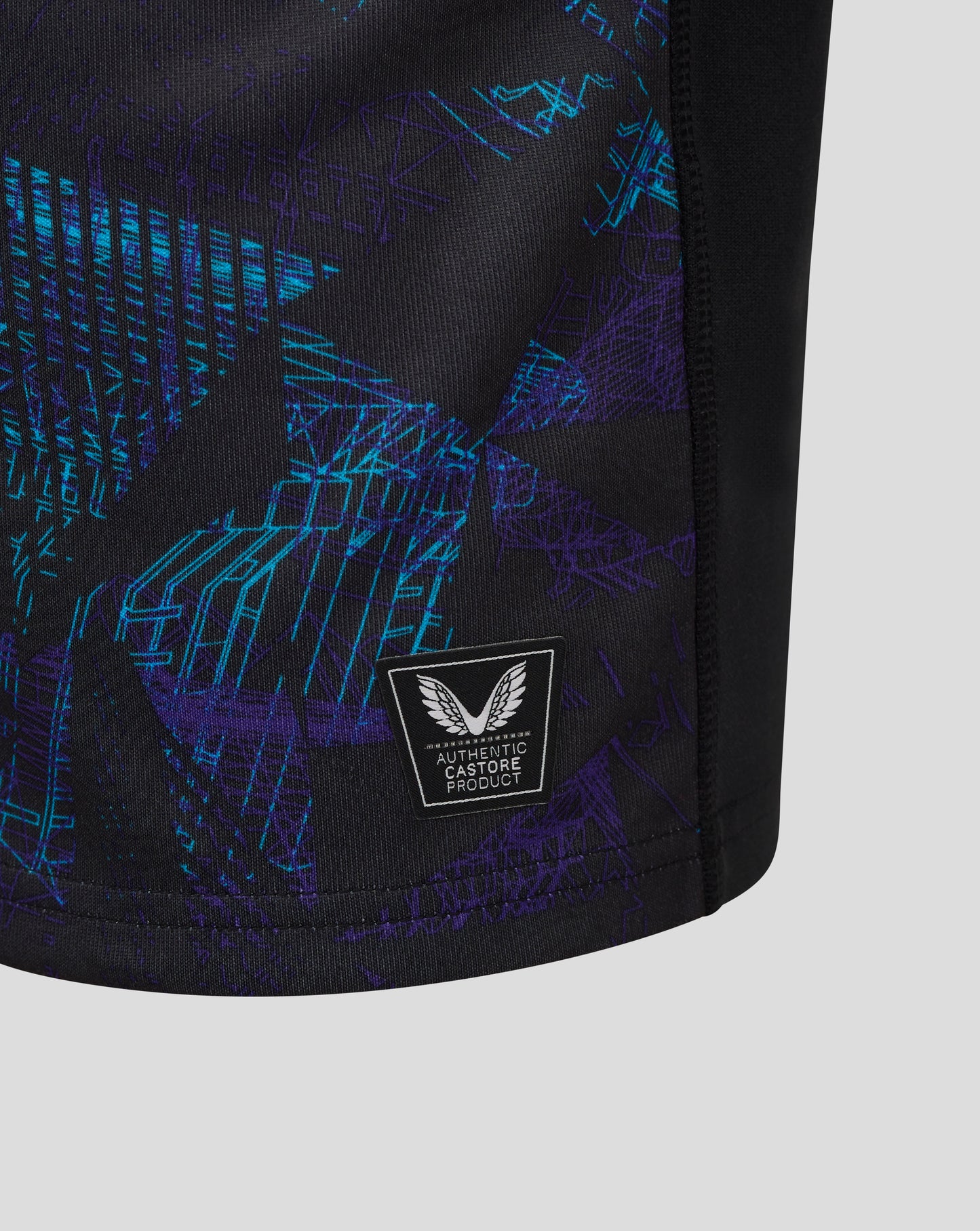 Close up of dark jersey with blue purple graphic and Castore badge