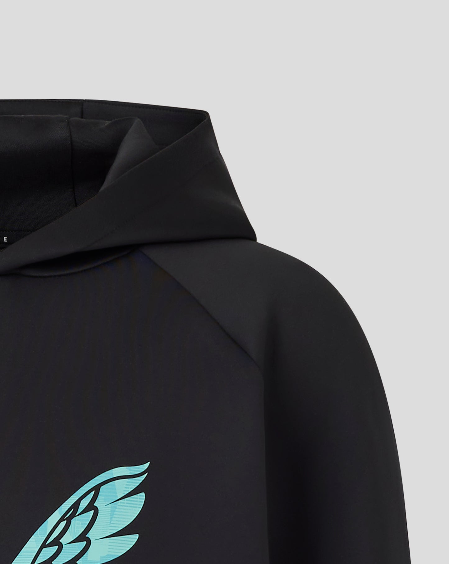Close up of turquoise wing emblem on the chest of the black hoodie