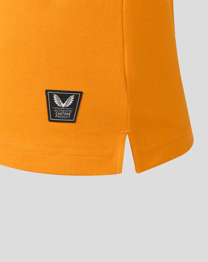 Close view of shield patch on orange jersey with authentic Castore product label.