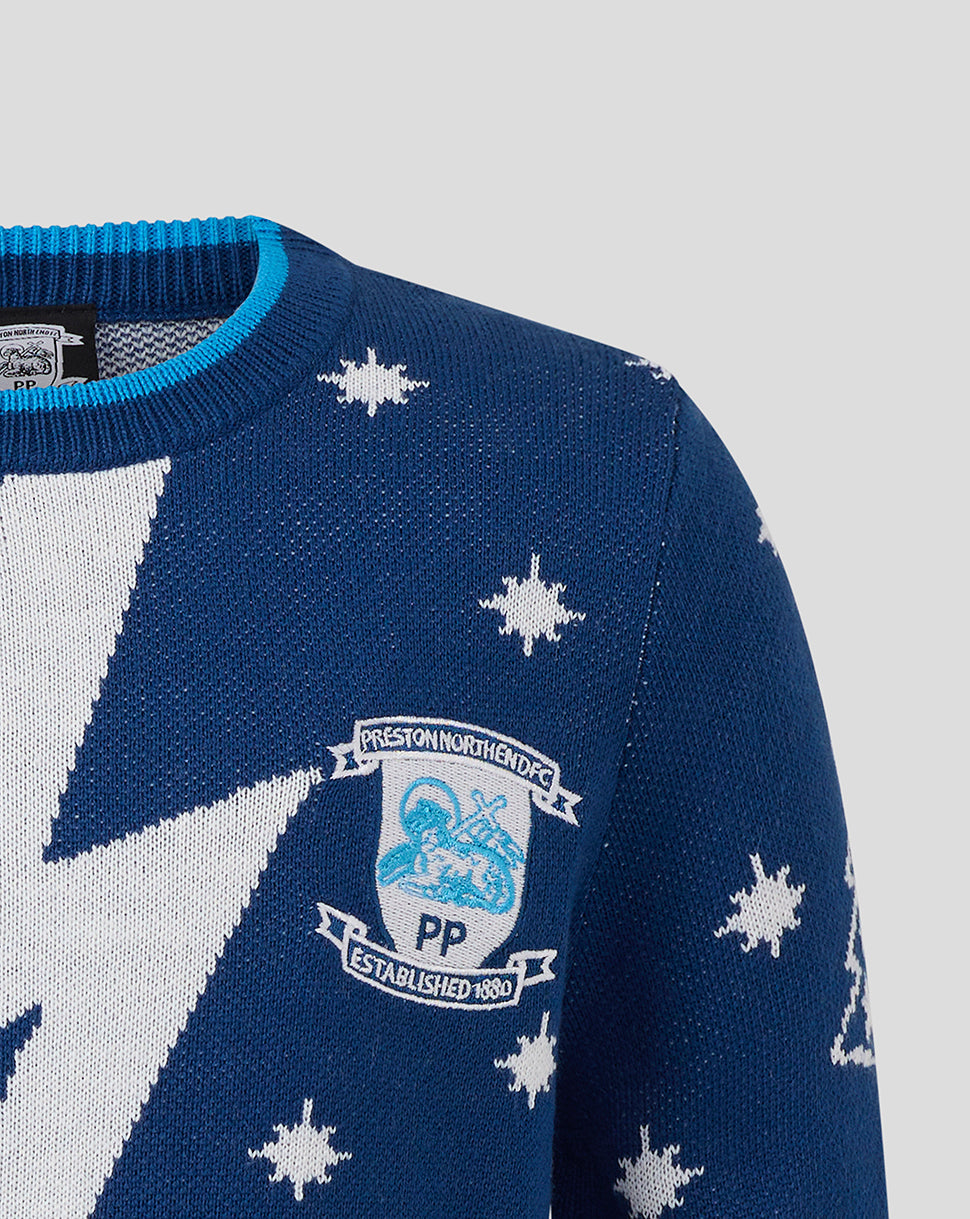 Close up of Preston North End Junior Christmas jumper with crest and white star pattern on blue knit.