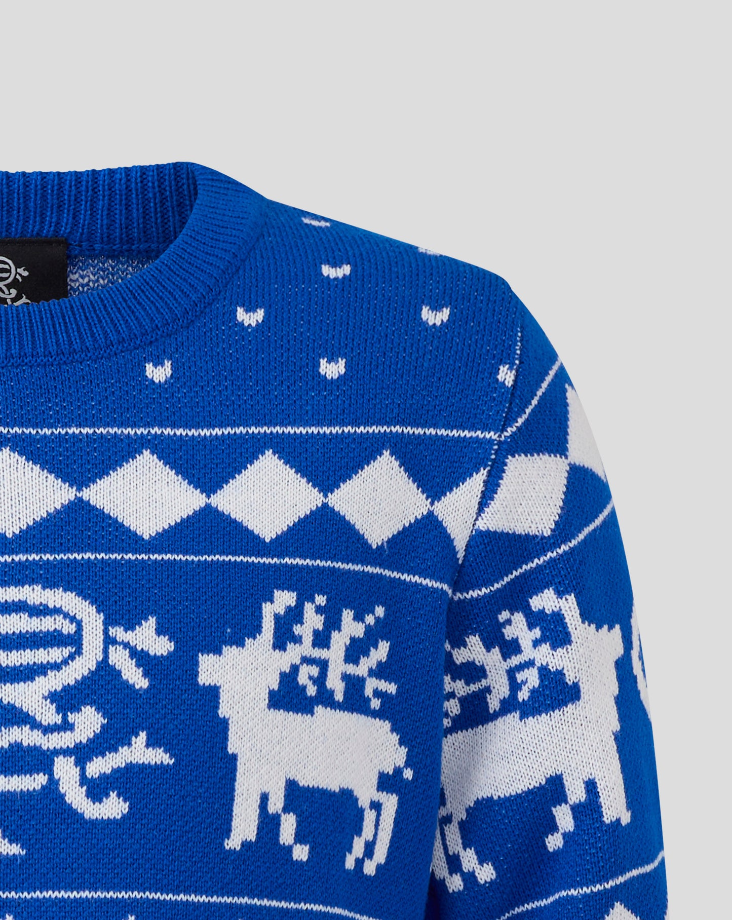 Close up of a blue Rangers junior Christmas jumper with white zigzag pattern and small knitted motifs