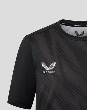 Front close up of black Leicester Tigers junior warm up shirt with white winged crest and Castore branding near the collar.