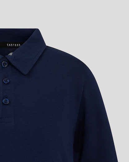 Close-up of navy polo showing the collar and button placket with blue buttons.