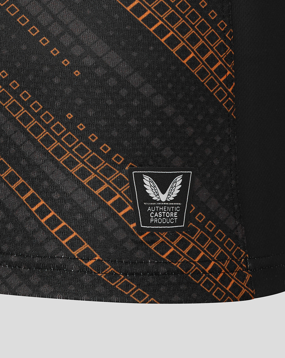 Close up of black jersey fabric with orange grid pattern and authentic Castore product badge