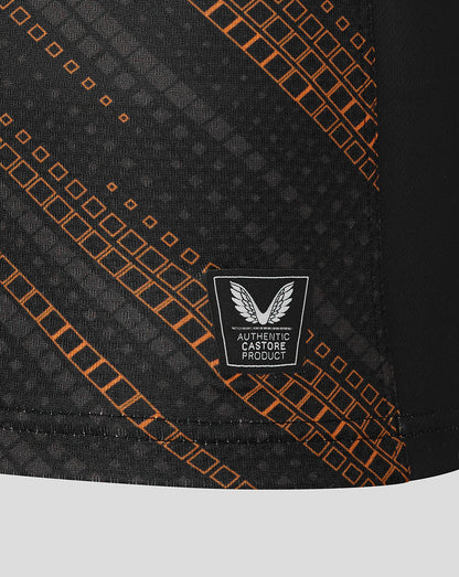 Close up of black jersey fabric with orange grid pattern and authentic Castore product badge