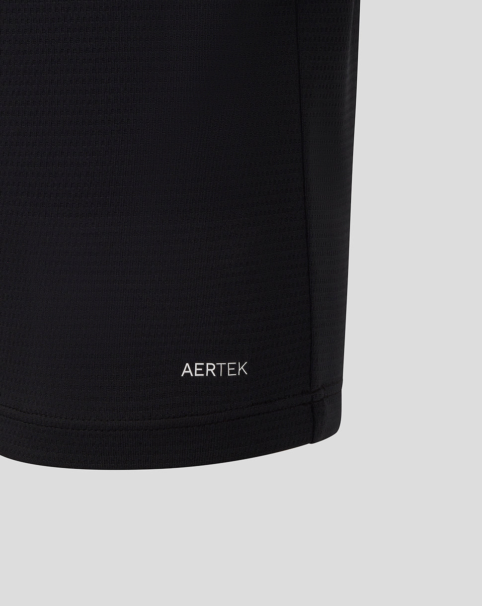 Close up of black Official Haas Team polo fabric showing AERTEK moisture wicking branding at the hem