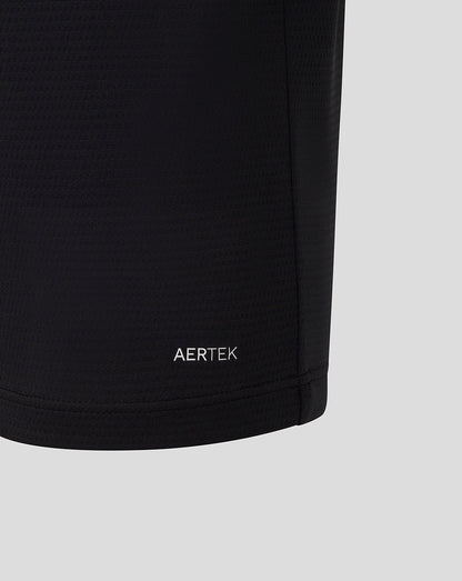 Close up of black Official Haas Team polo fabric showing AERTEK moisture wicking branding at the hem