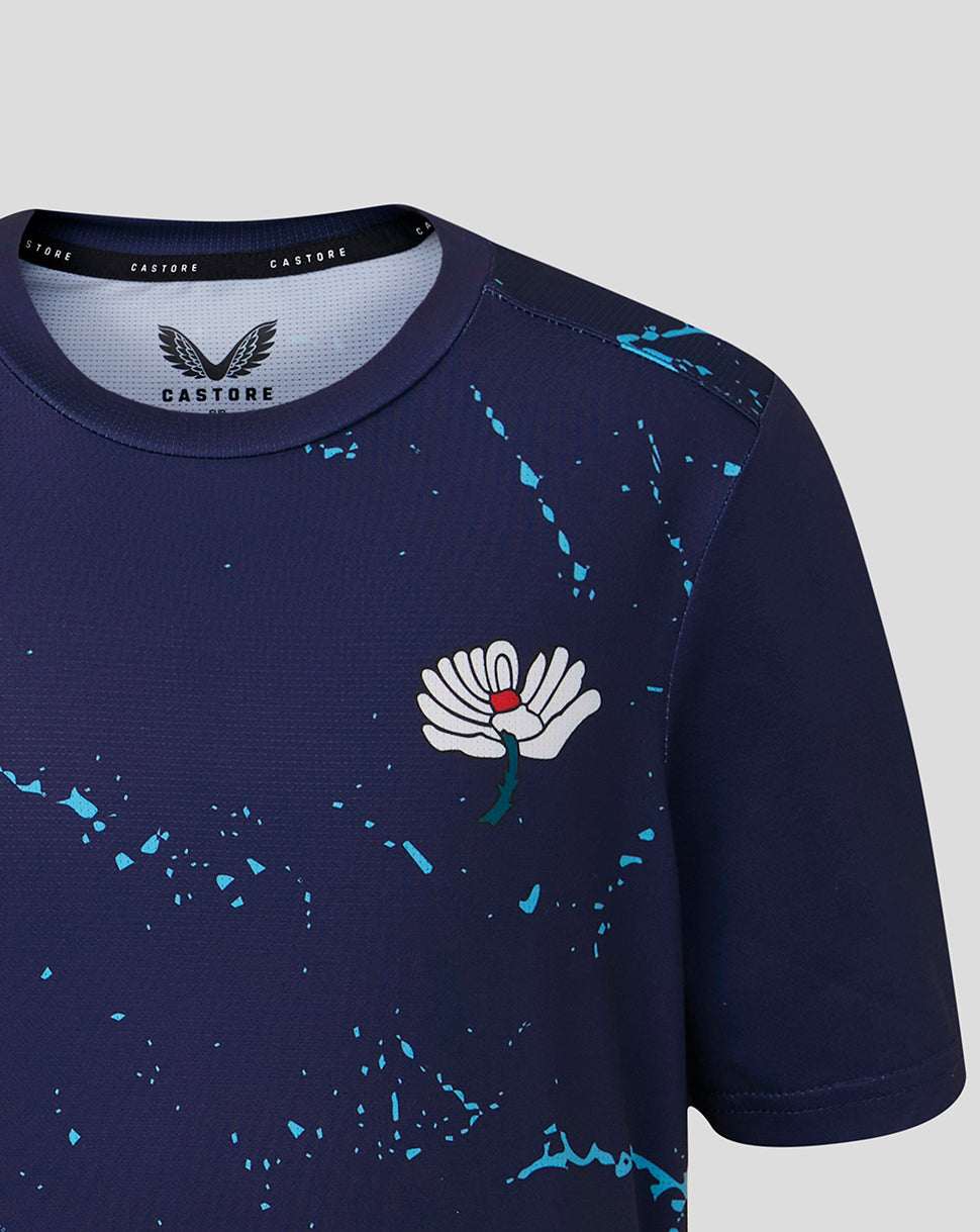 Navy blue athletic shirt with white flower design and 'Castore' branding on a light gray background