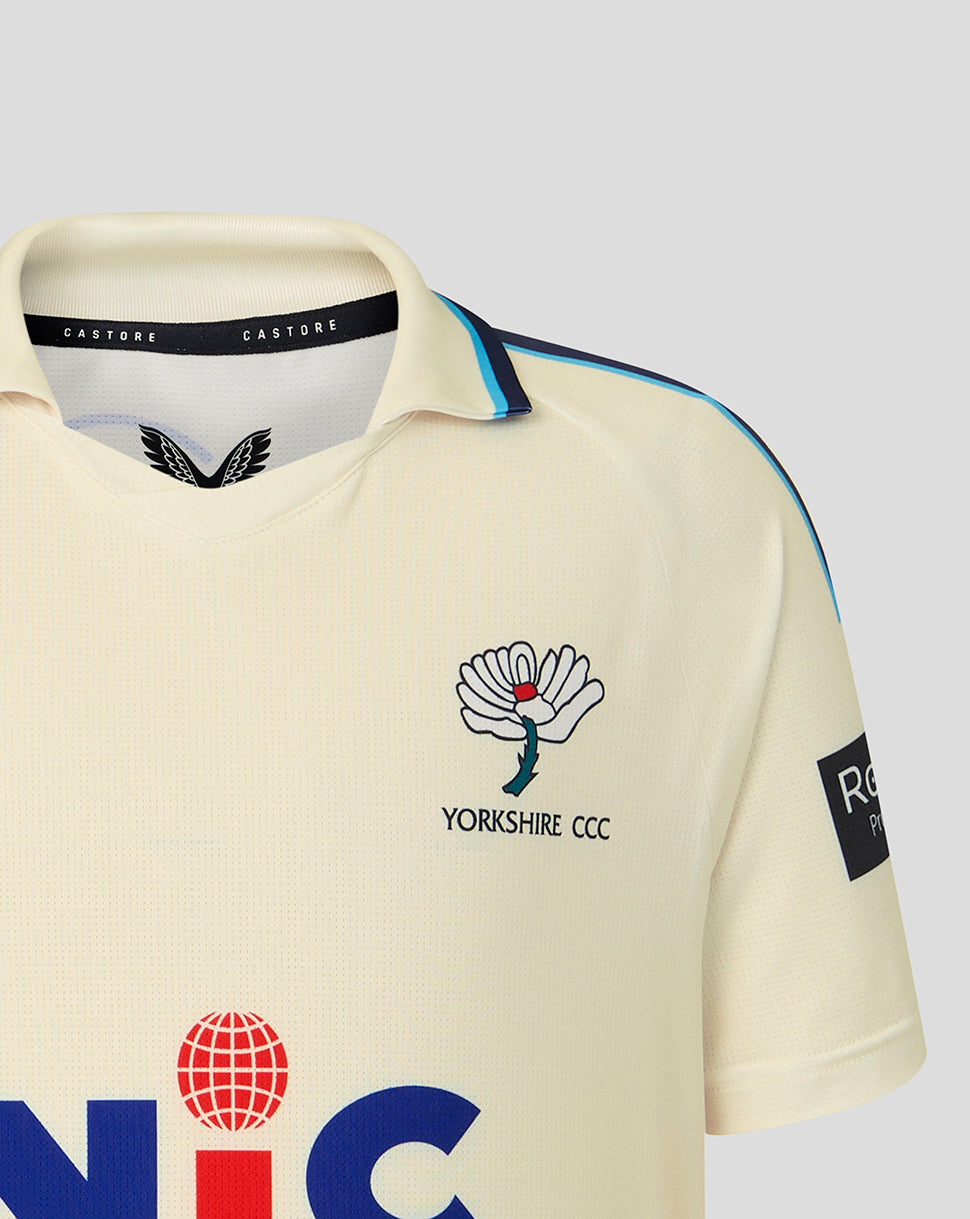 Beige sports jersey with logos on a light gray background