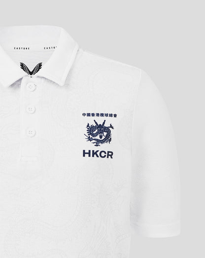 White polo shirt with embroidered logos on a light gray background