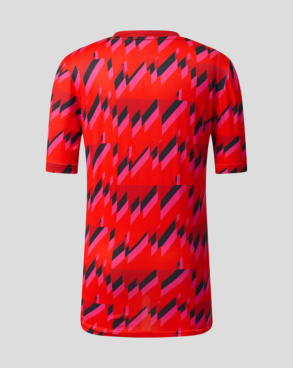 Back view of a red Welsh Fire junior training T shirt with an all over pink and black geometric pattern
