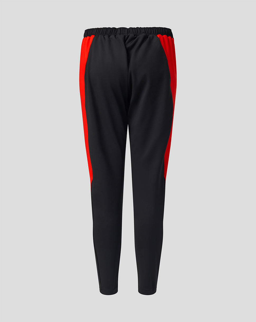 Angled front view of black athletic pants with red side stripe and Welsh Fire branding