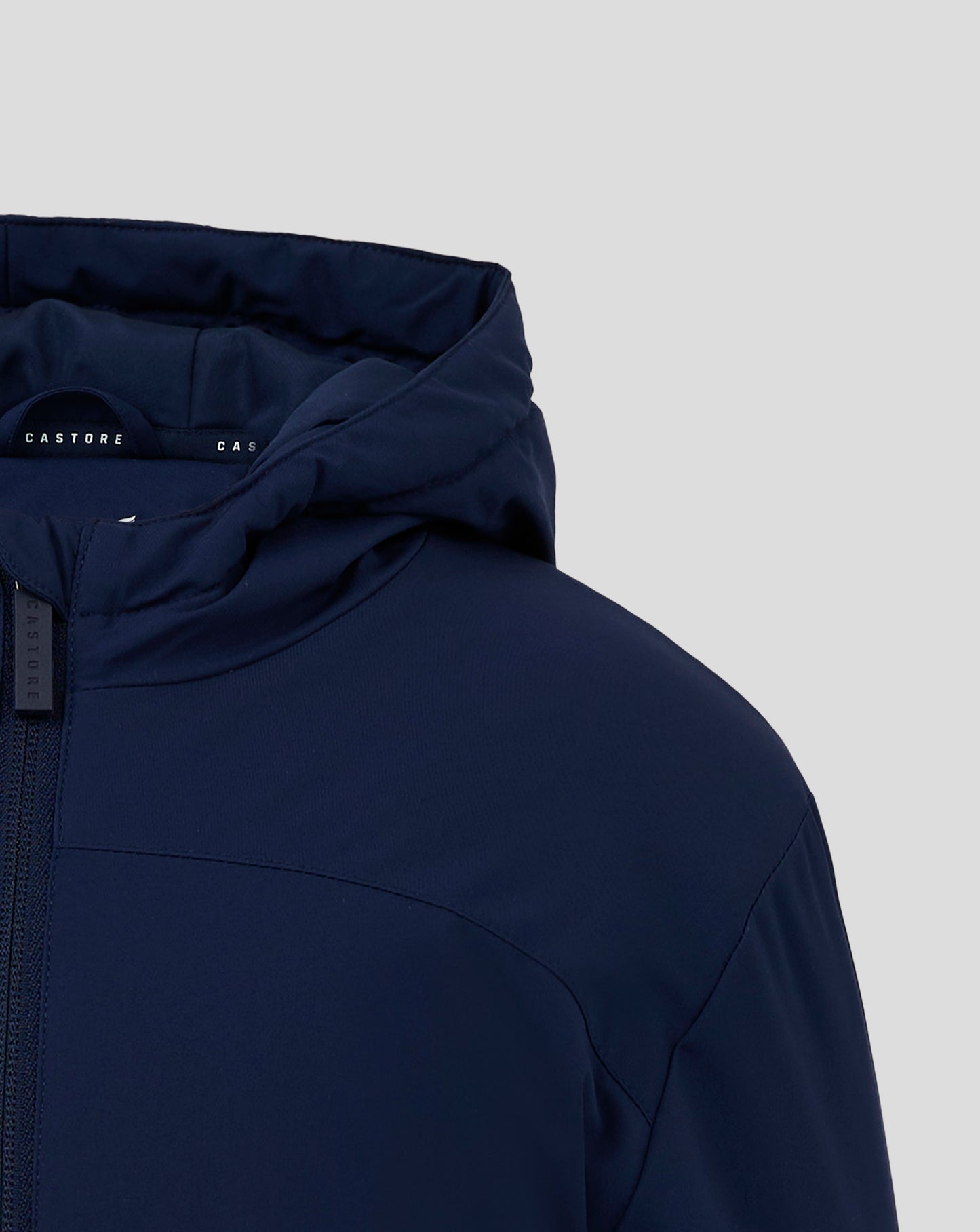Detail of navy hooded jacket with interior Castore branding and a visible vertical zipper pull.