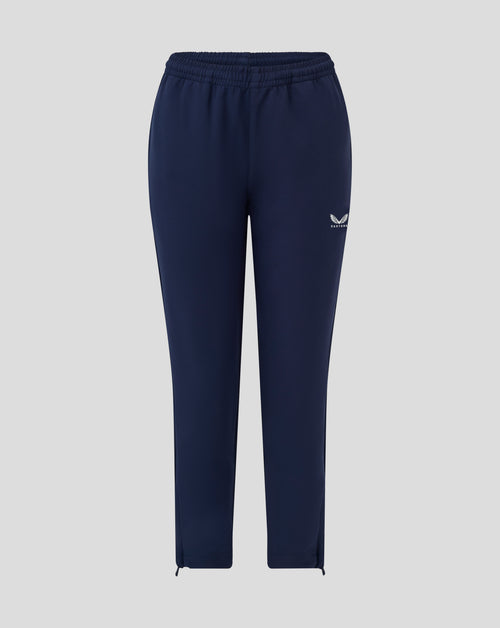 Back view of navy junior track pants with elastic waistband and small Castore logo on the thigh