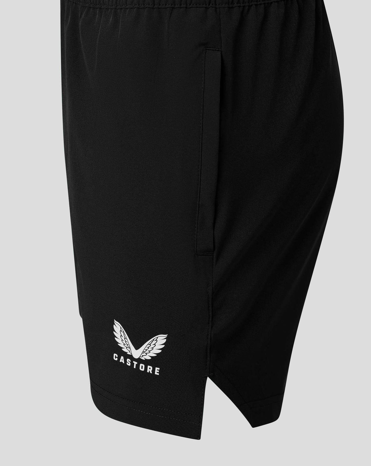 Close up of black Junior Woven Training Short showing a zip pocket and Castore logo.