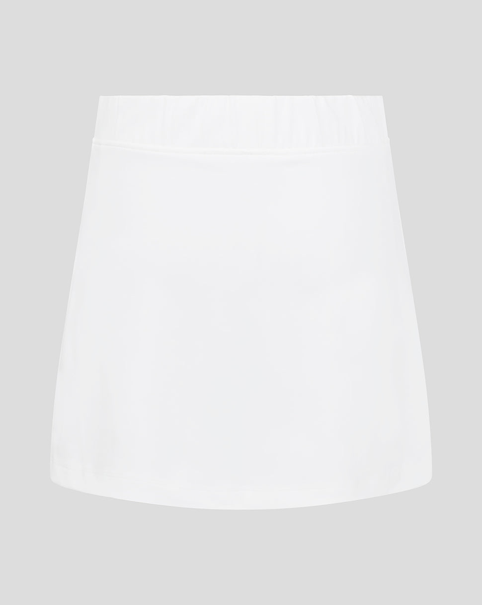Front view of white junior skort with elasticated waistband and Castore logo at hem