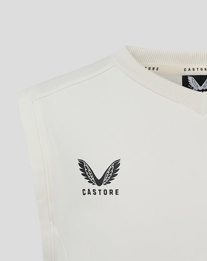 Cannoli Cream junior cricket vest with a black winged Castore logo on the chest.