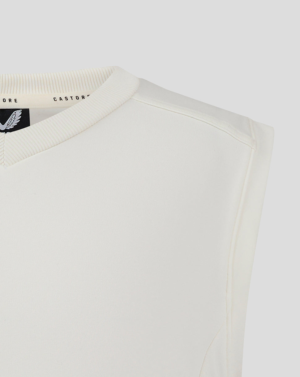 Close-up of the cream vest neckline showing ribbed V neck and Castore label inside.