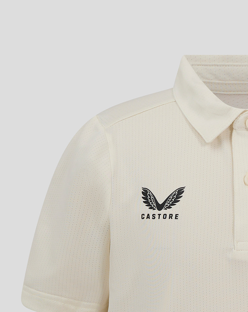 Front close-up of Cannoli Cream Junior Cricket Tech Playing Shirt with heat sealed Castore logo on chest.