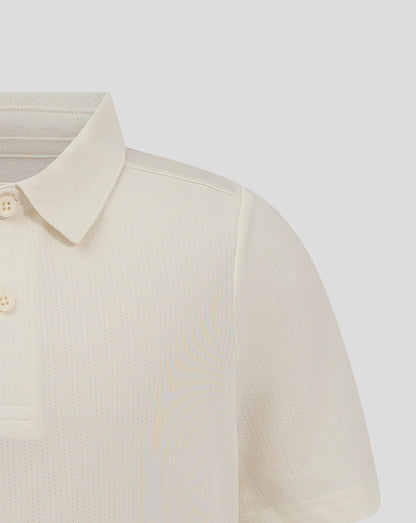 Shoulder and chest close-up of Cannoli Cream Junior Cricket Tech Playing Shirt featuring forward shoulder seam and Castore branding.