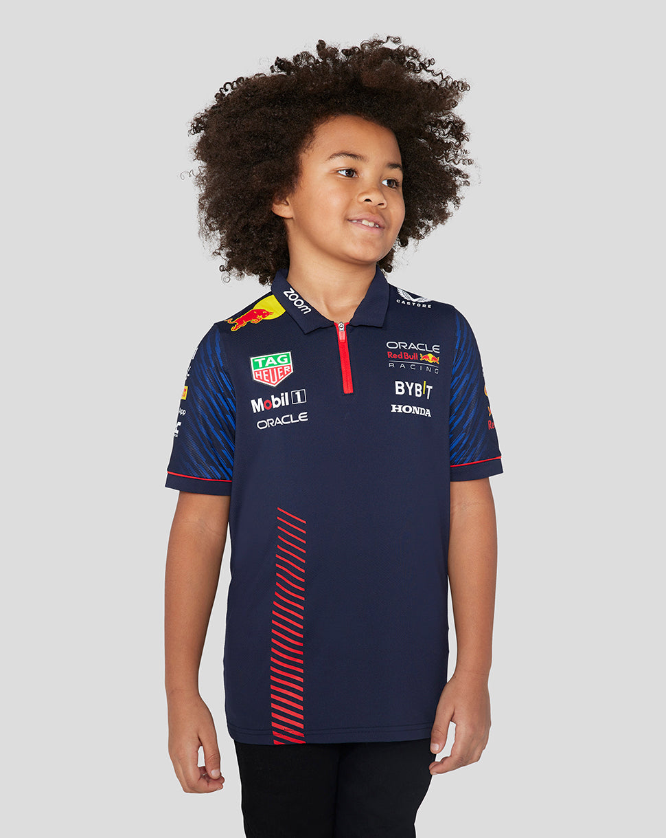 Young child wearing a navy Red Bull Racing polo with sponsor logos on the chest and a red zipper at the collar