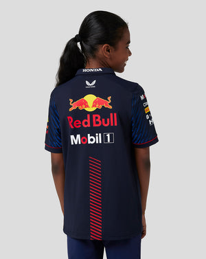 Back view of junior in navy Oracle Red Bull Racing polo showing large Red Bull logo on the back.