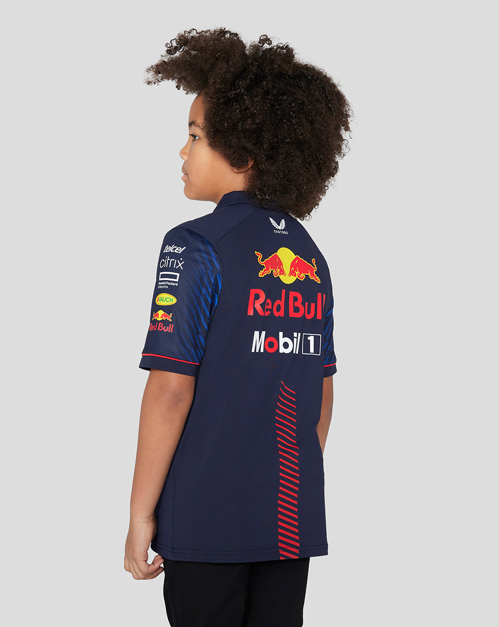 Back view of a child in a navy Red Bull Racing polo showing a large Red Bull graphic and sponsor branding