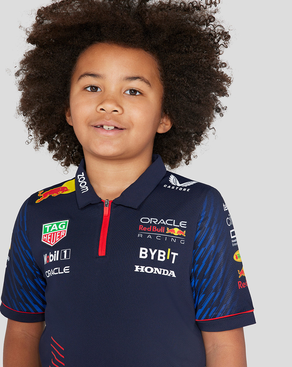 Front view of a young racer wearing a navy Night Sky polo with multiple sponsor logos on the chest