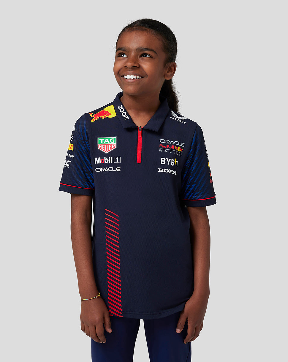 Portrait of a girl in a navy Oracle Red Bull Racing polo with multiple sponsor logos on the chest.