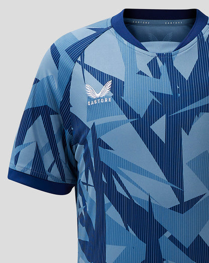 Front close up of Aston Villa junior 23/24 third shirt showing crest on the chest and geometric blue pattern.