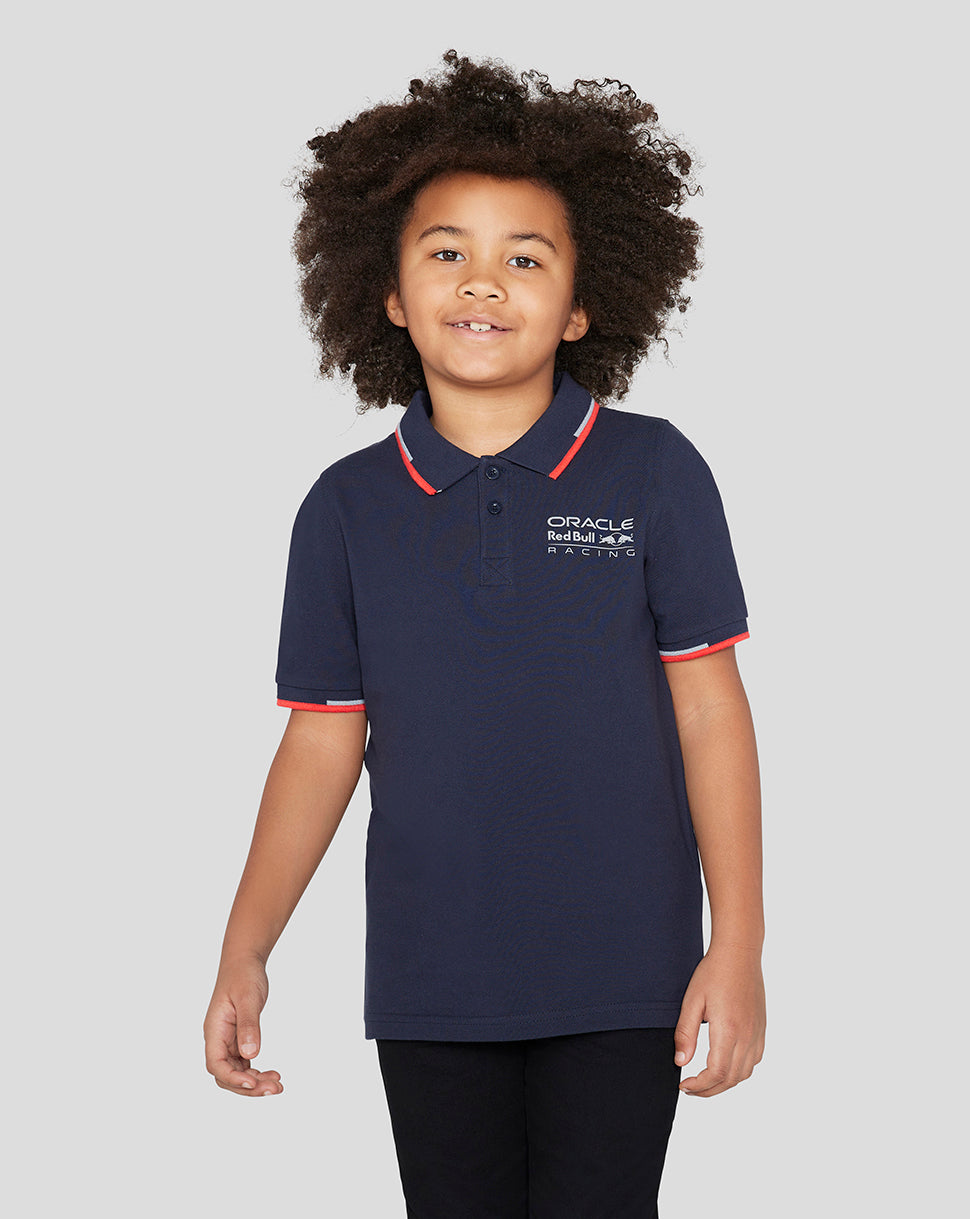 Child wearing navy Night Sky Oracle Red Bull Racing Junior Core Polo with red collar trim and logo on chest