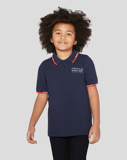 Child wearing navy Night Sky Oracle Red Bull Racing Junior Core Polo with red collar trim and logo on chest