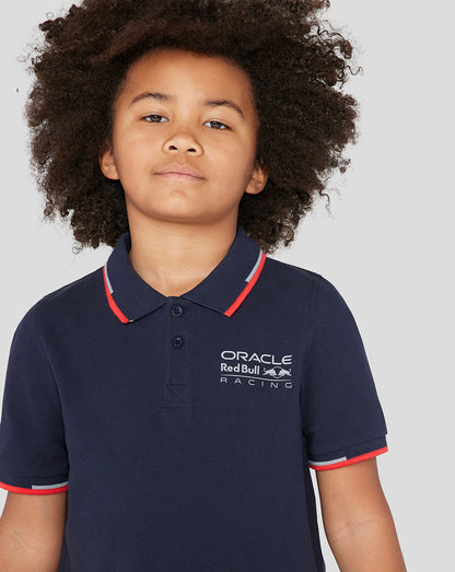 Smiling child in Night Sky navy Oracle Red Bull Racing Junior Core Polo with logo on chest