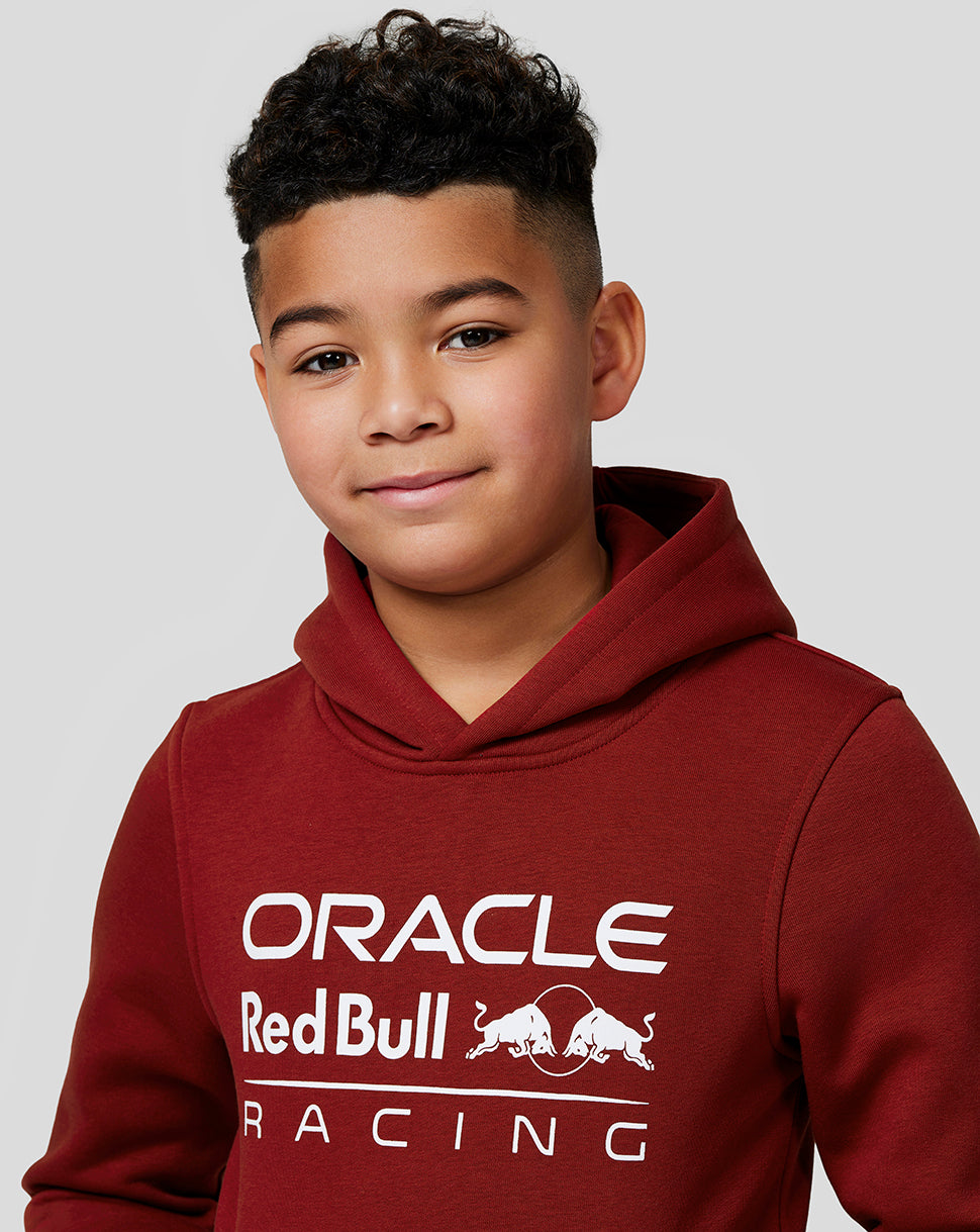 Junior wearing winery red Oracle Red Bull Racing hoodie with front logo
